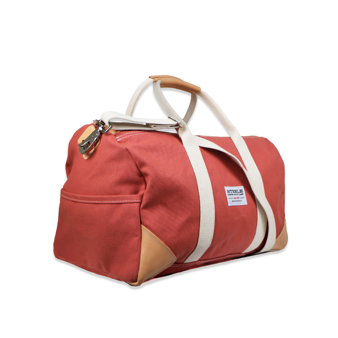Red duffel bag with white strap on a white background