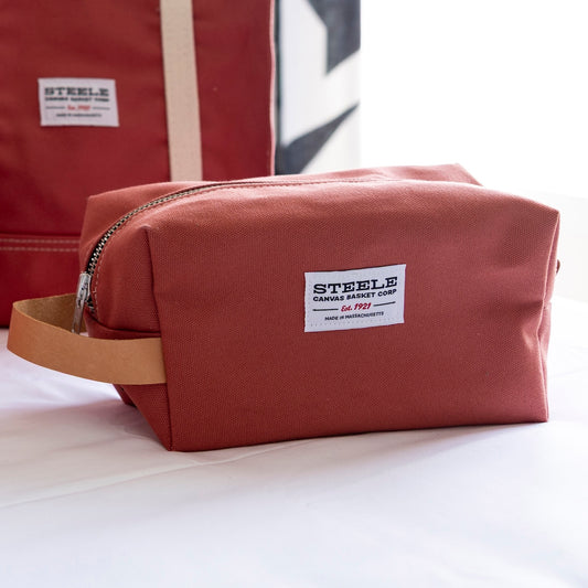 Red toiletry bag with 'Steele' label on a white background