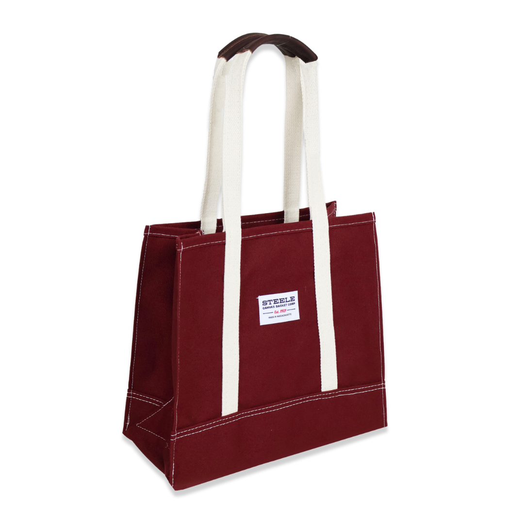 Red tote bag with white handles on a white background