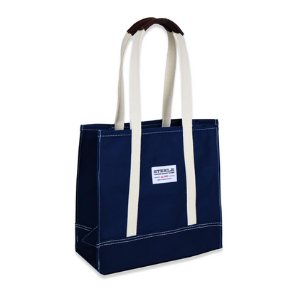 Navy tote bag with white handles on a white background