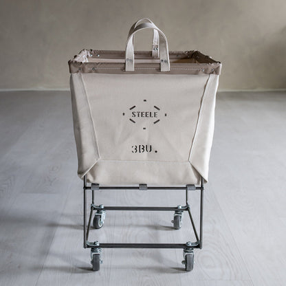 Cart with a large beige bag featuring a brand logo on a plain background