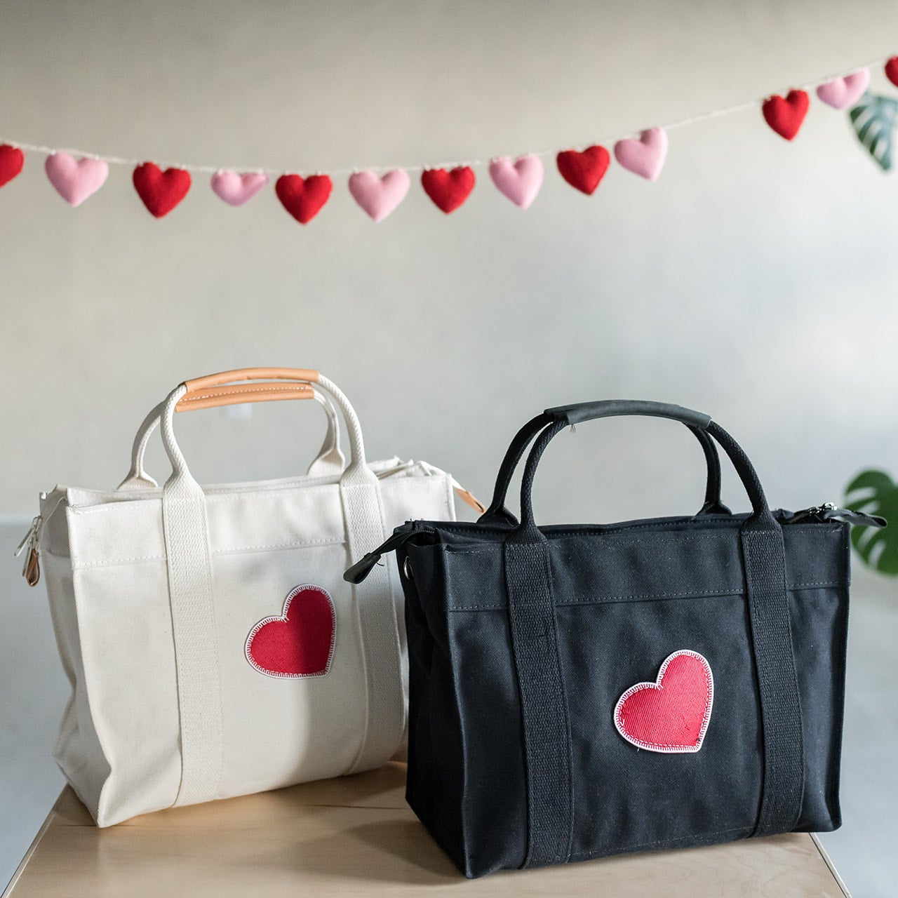 valentine day totes in black and natural canvas sitting next to eachother