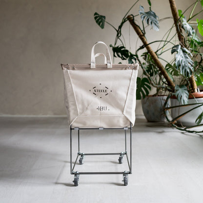Beige laundry cart with wheels in a room with plants