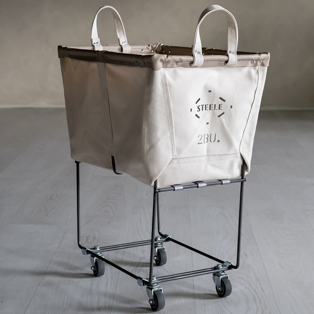 Beige laundry truck with a bag on a gray floor and background