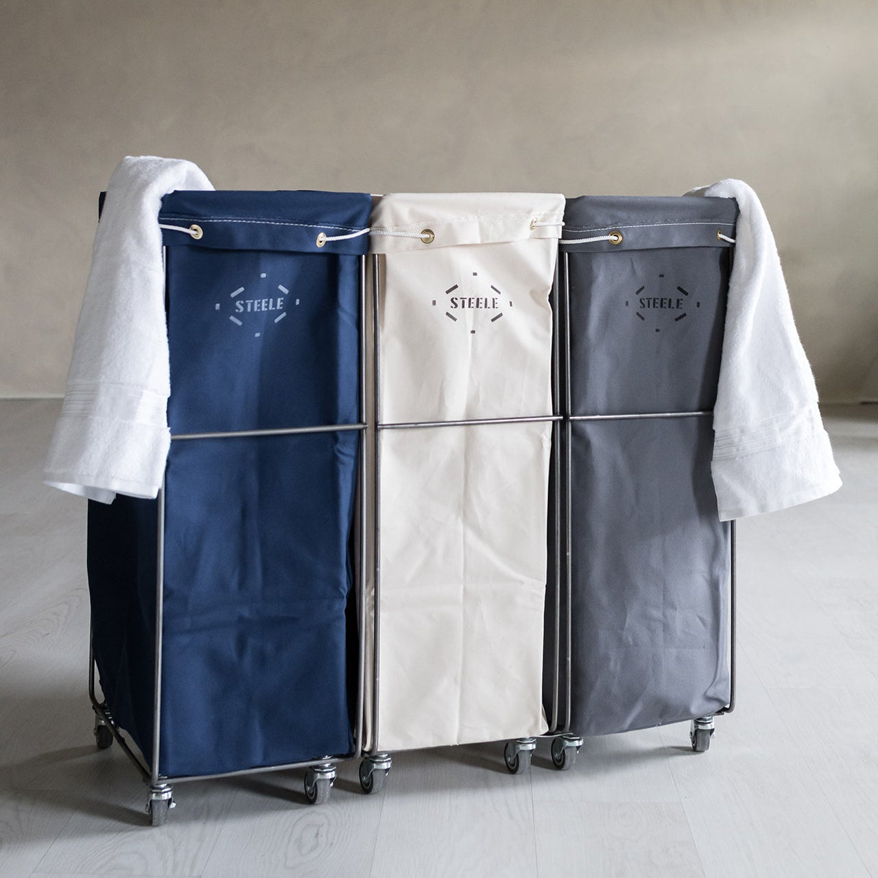 Three-section laundry sorter with clothes on a neutral background