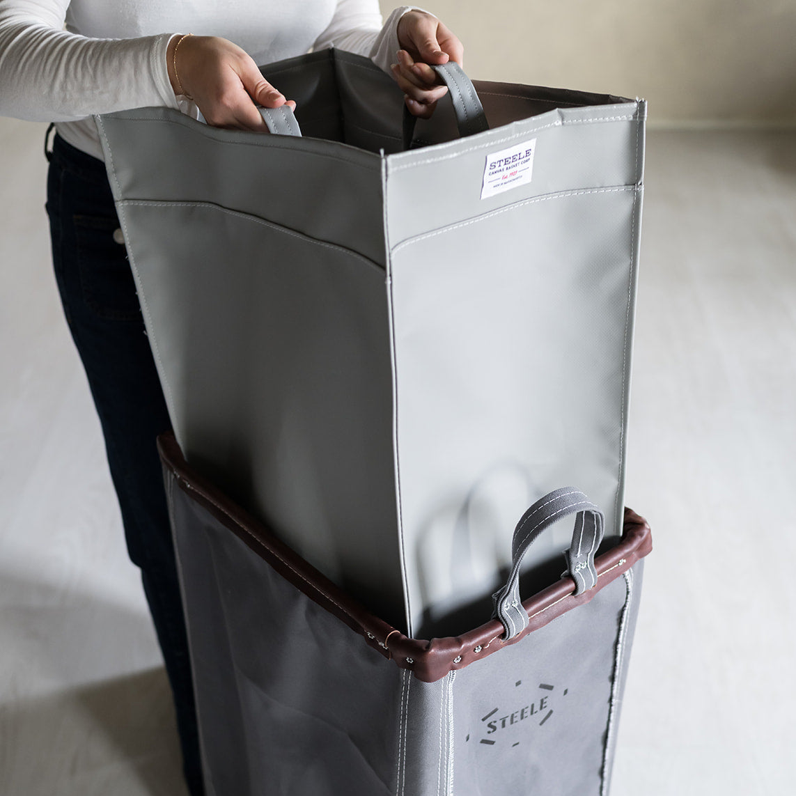 Gray storage bag with wheels and handles on a light gray background