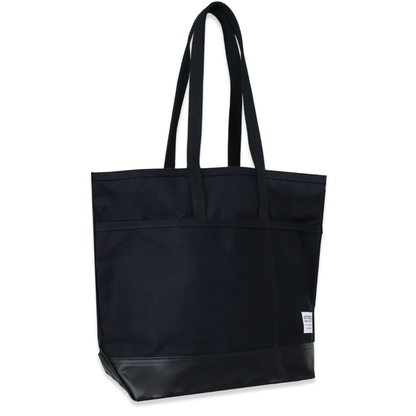 Black tote bag with a small white label on a white background