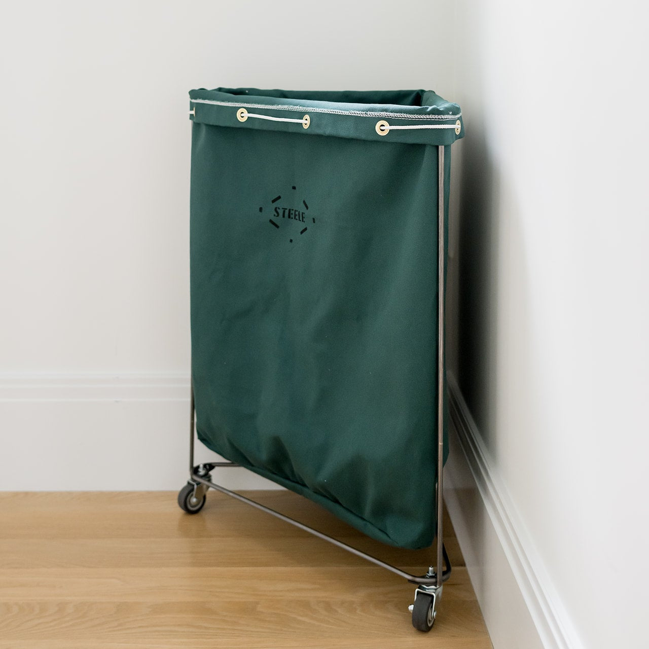 corner laundry hamper in hunter green from a side angle