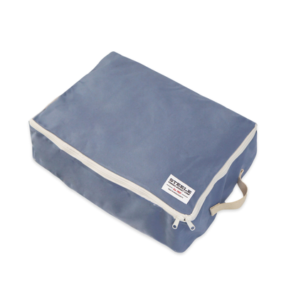 A rectangular blue fabric storage bag with a zipper closure, beige piping, and a beige carrying handle, shown on a plain white background.