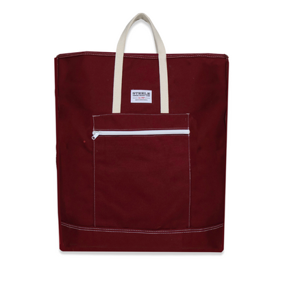 Maroon tote bag with white zipper pocket and handles on a white background