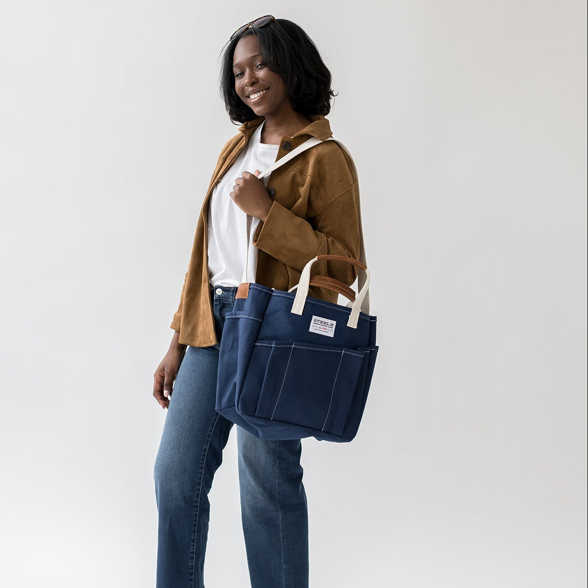 woman posing with navy blue utility tote bag