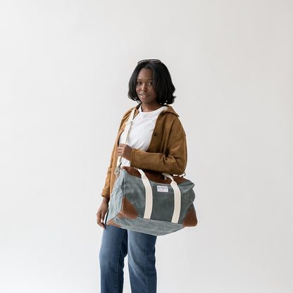 Person holding a green and brown bag against a white background