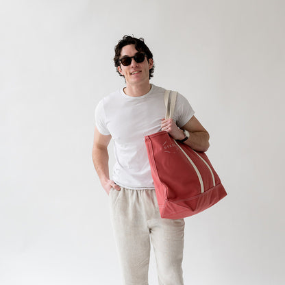 man holding a red tote bag
