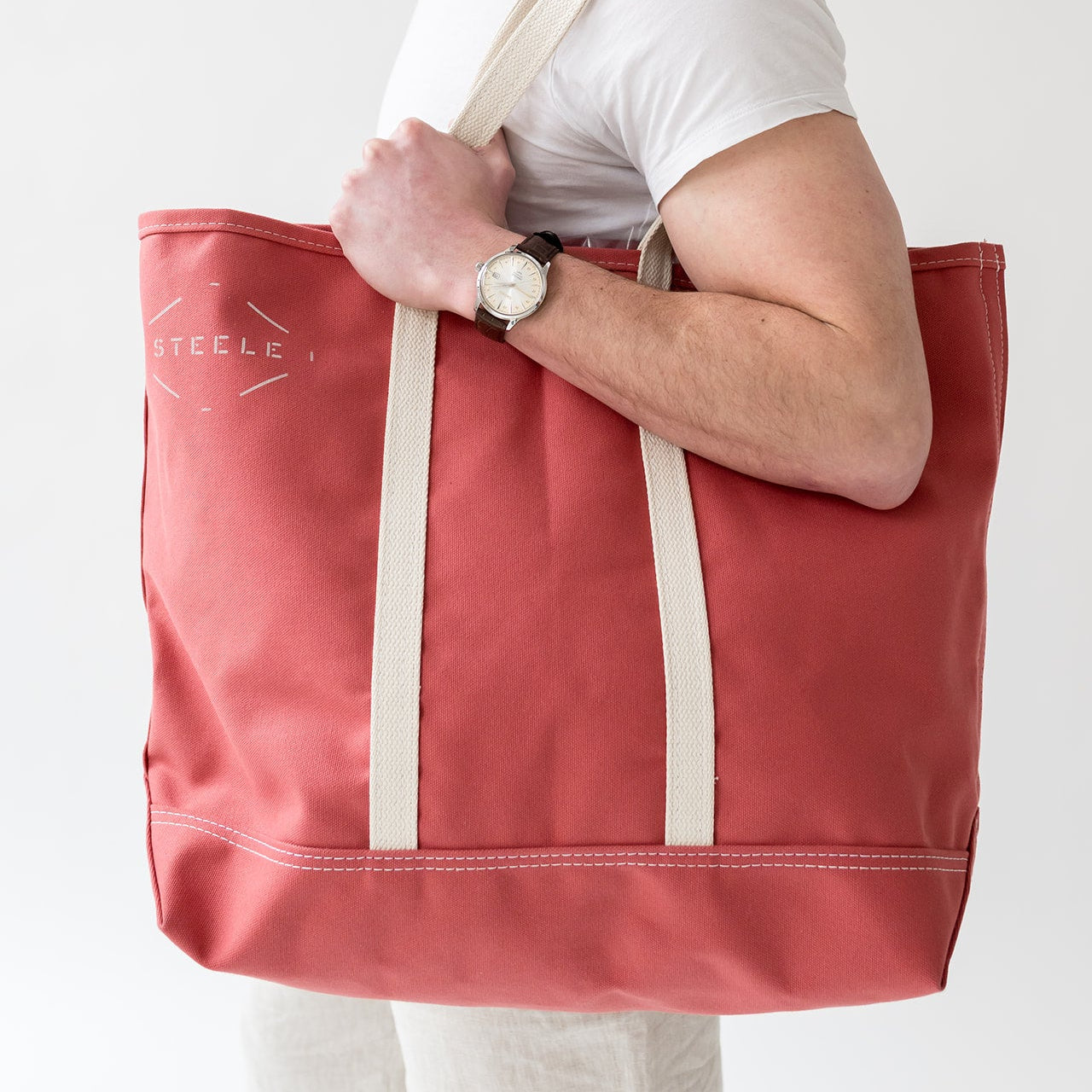 man holding a red tote bag