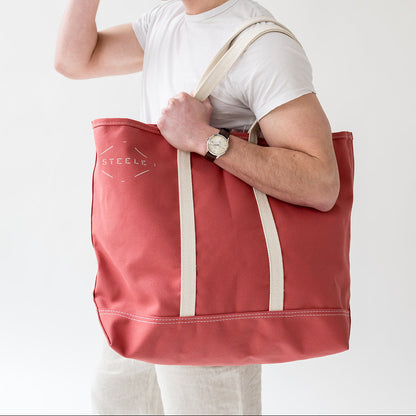 man holding a red tote bag