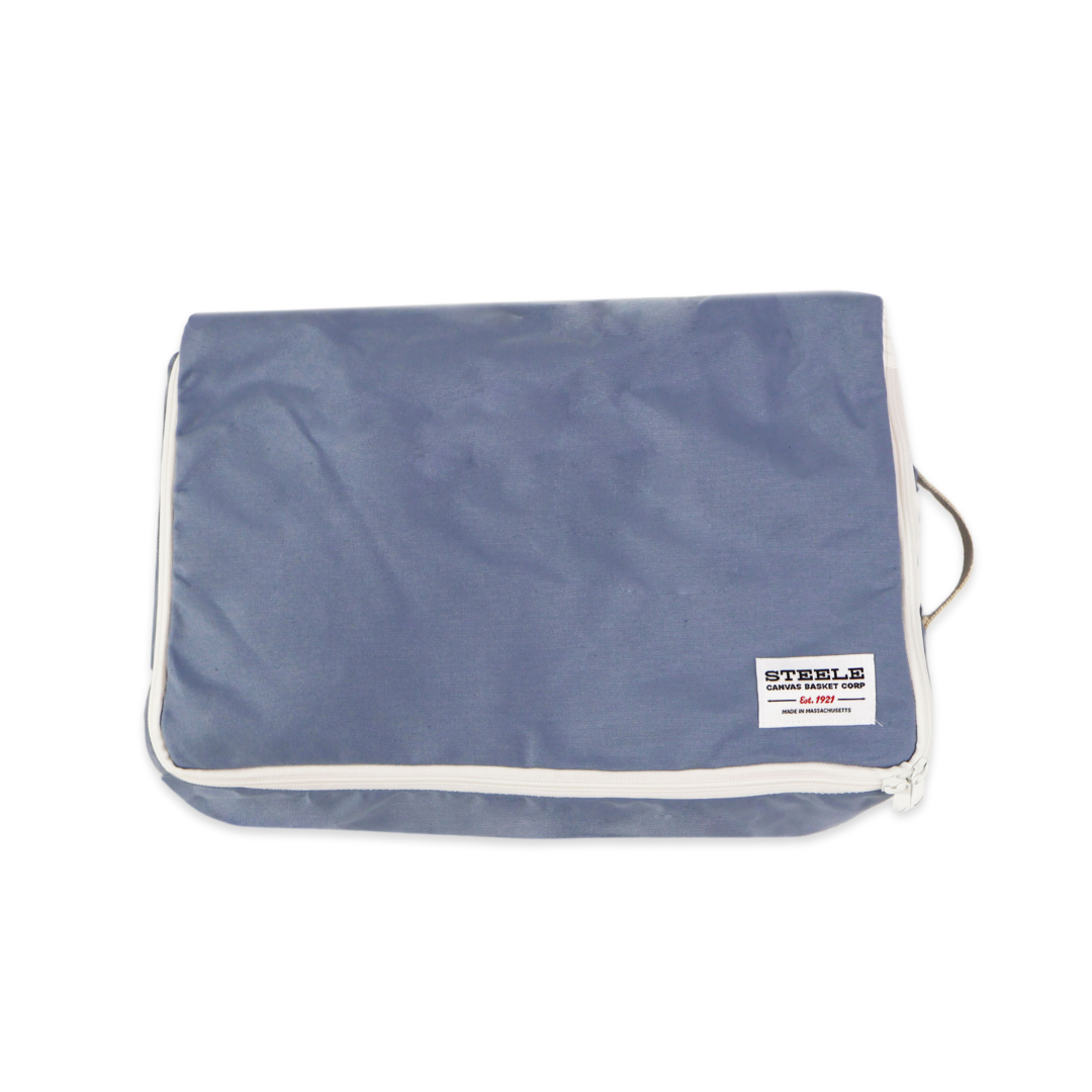 A blue zippered luggage or travel pouch with white piping and a small white brand label on the front, shown on a plain white background.