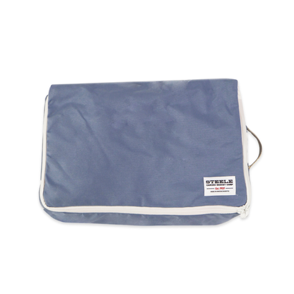 A blue zippered luggage or travel pouch with white piping and a small white brand label on the front, shown on a plain white background.