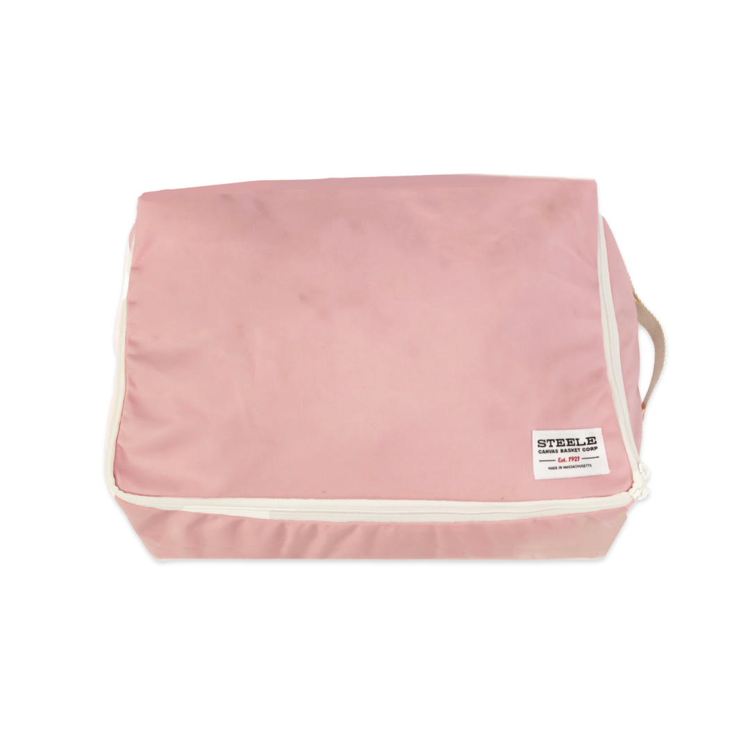 A pink zippered travel packing cube with white piping and a small white brand label on the front, shown on a plain white background.