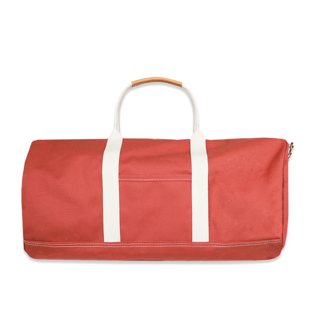 Red duffel bag with white handles on a white background