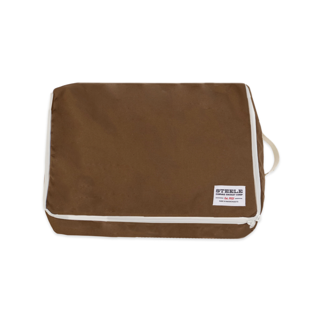 A brown canvas travel pouch with white piping and a white zipper, featuring a small white brand label on the bottom right corner. The brand 'STEELS' is clearly visible.