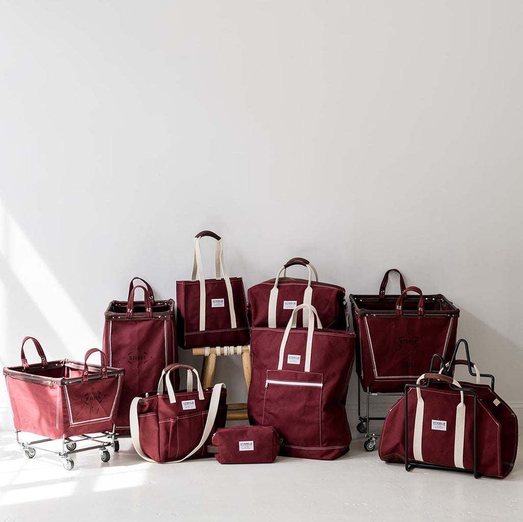 Collection of red canvas bags and baskets on a light background